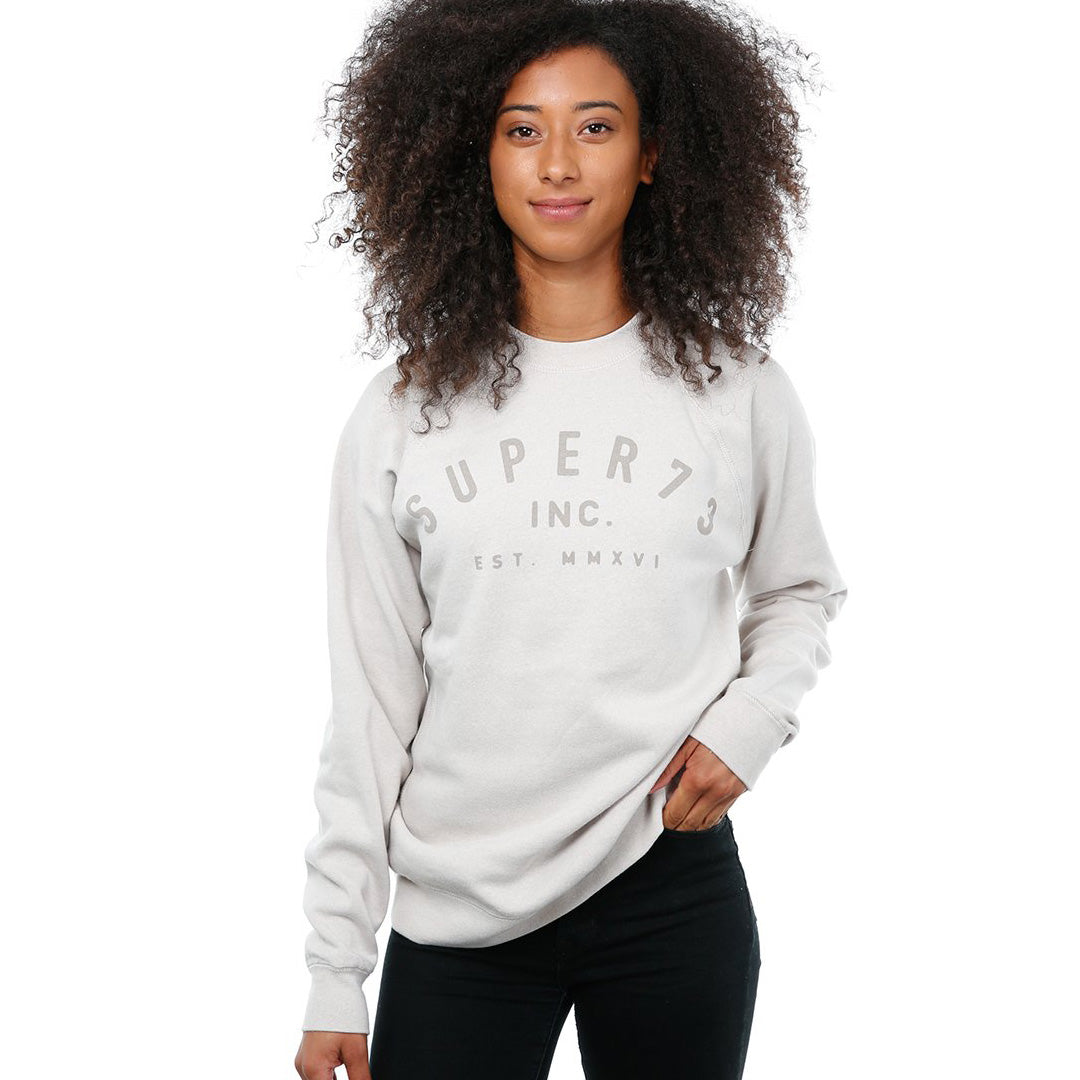 Front view of female model in Stone Classic Crew Sweatshirt on white background.