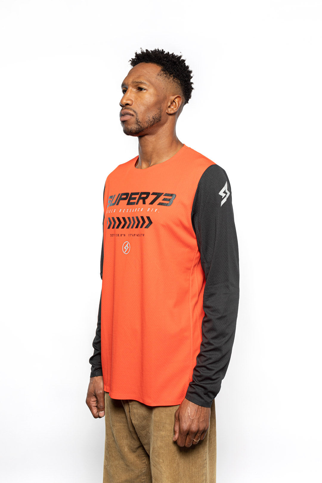 Male model side view of orange Premium long sleeve athletic moto hoon jersey.