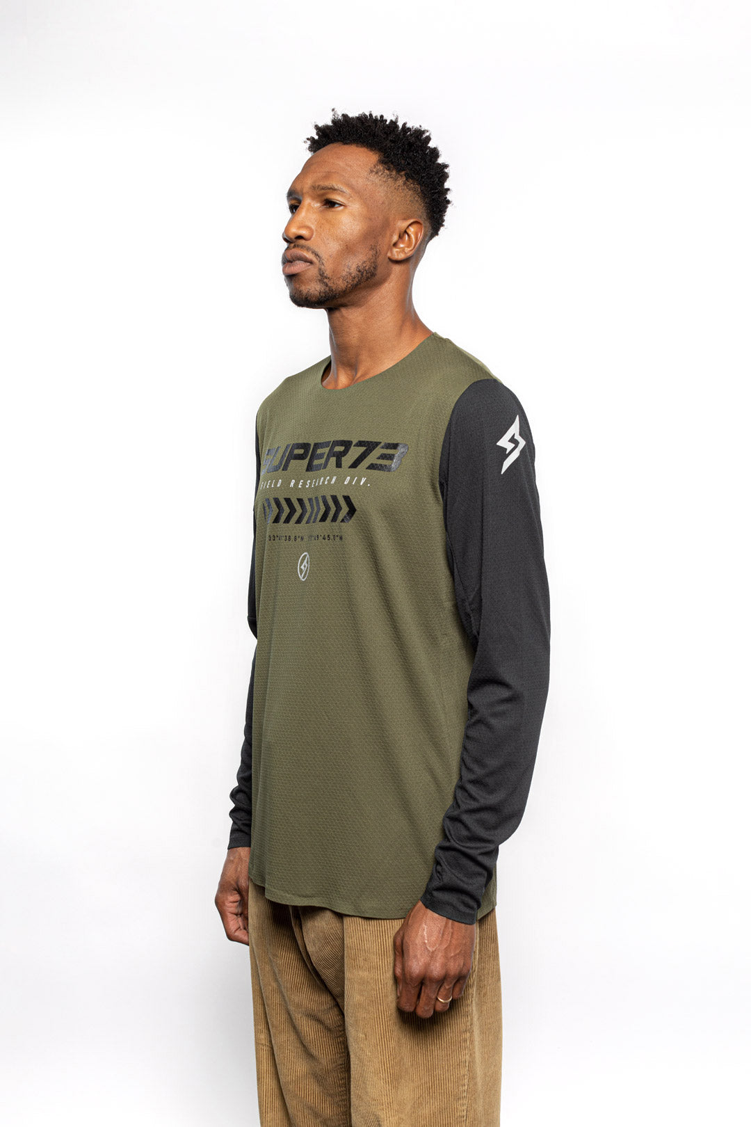 Male model side view of black and olive Premium long sleeve athletic moto hoon jersey.