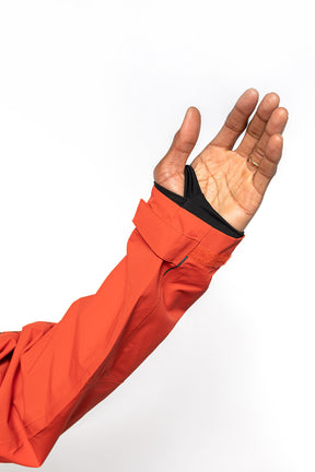 Sleeve detail shot of male model wearing Vale Packable Anorak in blood orange colorway.